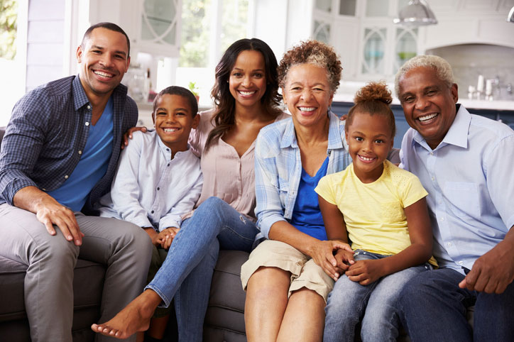 Estate planning. Multi-generational black family posing for portrait on couch in living room.