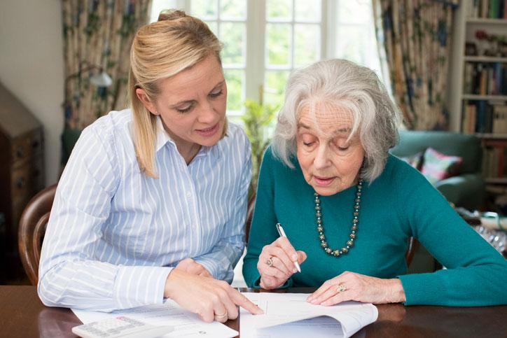 Woman helping senior woman with her estate planning documents